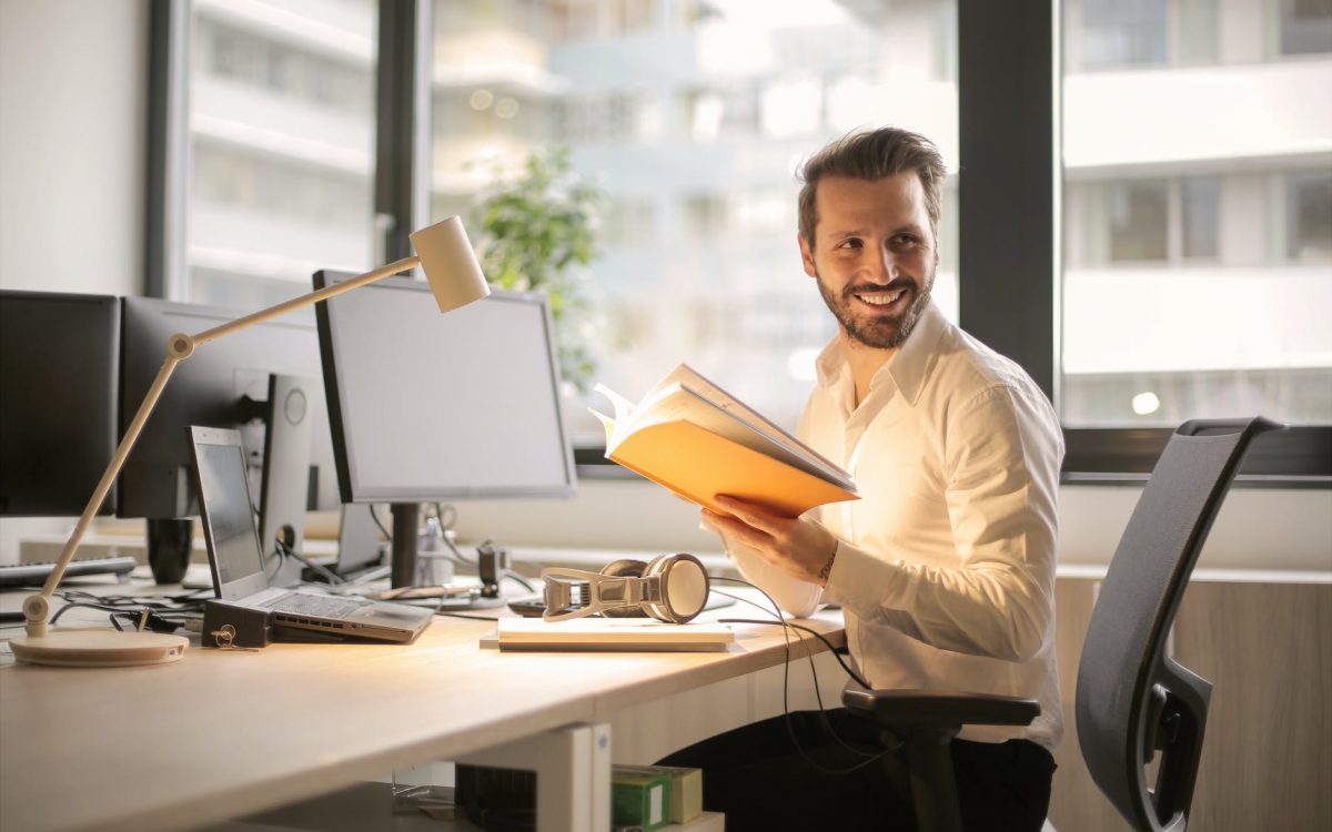 photo of man holding a book