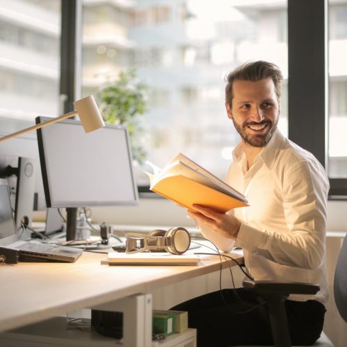 photo of man holding a book