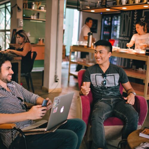 Photograph of Men Having Conversation Seating on Chair