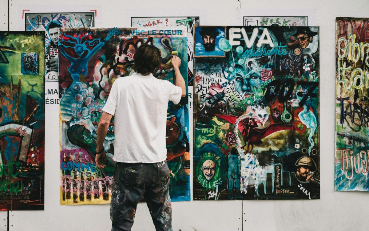 man wearing white shirt painting a wall