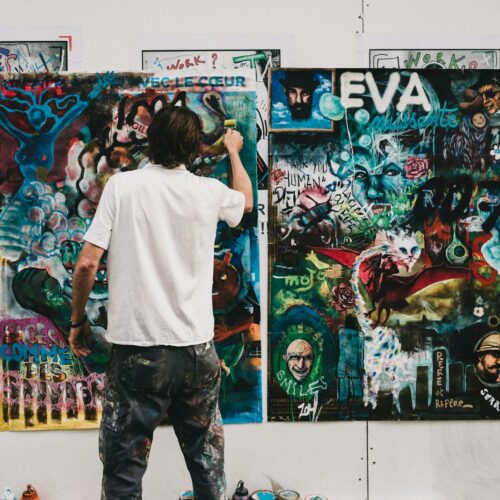 man wearing white shirt painting a wall